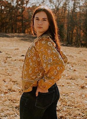 Allayna L. 这张照片是在田野里穿着橙色衬衫. 她是印第安纳连接职业学院的学生. 